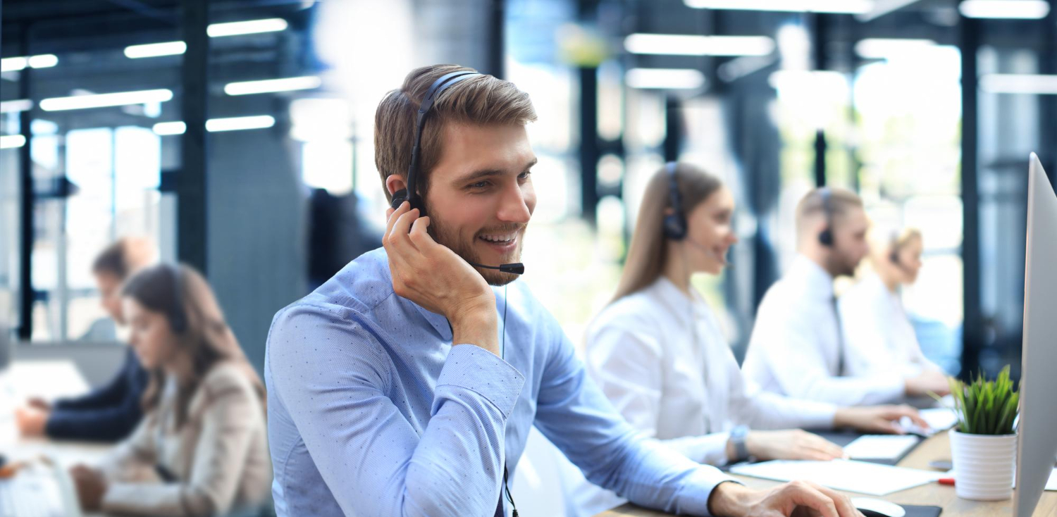 portrait-call-center-worker-accompanied-by-his-team-smiling-customer-support-operator-work (1)